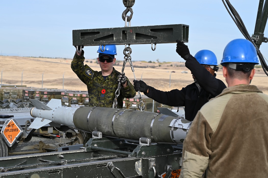 Royal Canadian Air Force Sgt. Kristjan Lindvere guides a hoist to move a bomb from the munitions assembly conveyor onto a trailer for transport during the exercise Iron Flag at the Air Force Combat Ammunition Center, Beale Air Force Base, California, Nov. 5, 2024