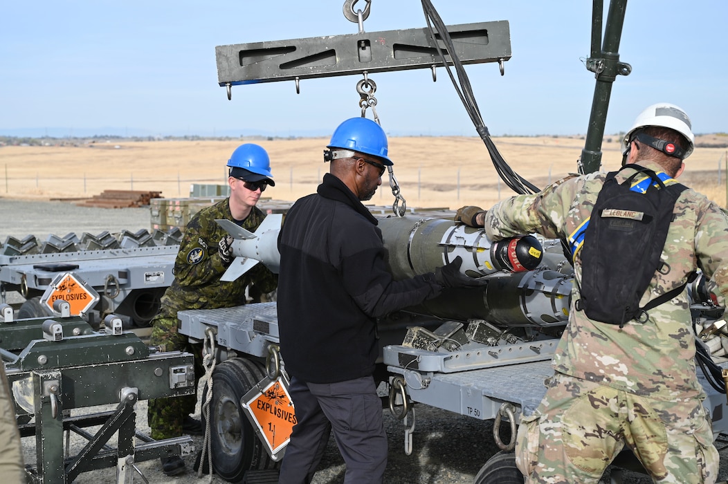 U.S. Air Force Airmen, and Sgt. Kristjan Lindvere of the Canadian Air Force, man the munitions assembly conveyor during hands on training with the Air Force Combat Ammunition Course (AFCOMAC) at Beale Air Force Base, California, Nov. 5, 2024