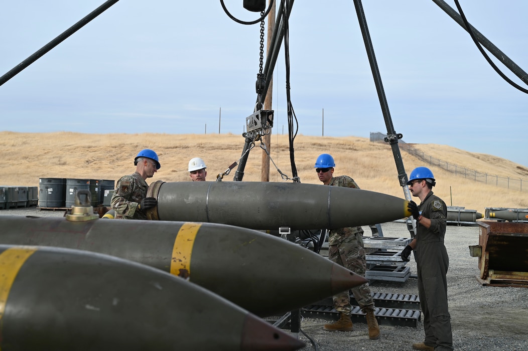 U.S. Air Force Airmen hoist bare munitions onto the munition assembly conveyor (MAC) during the Air Force Combat Ammunition Center’s Iron Flag practical exercise on Beale Air Force Base, California, Nov. 5, 2024