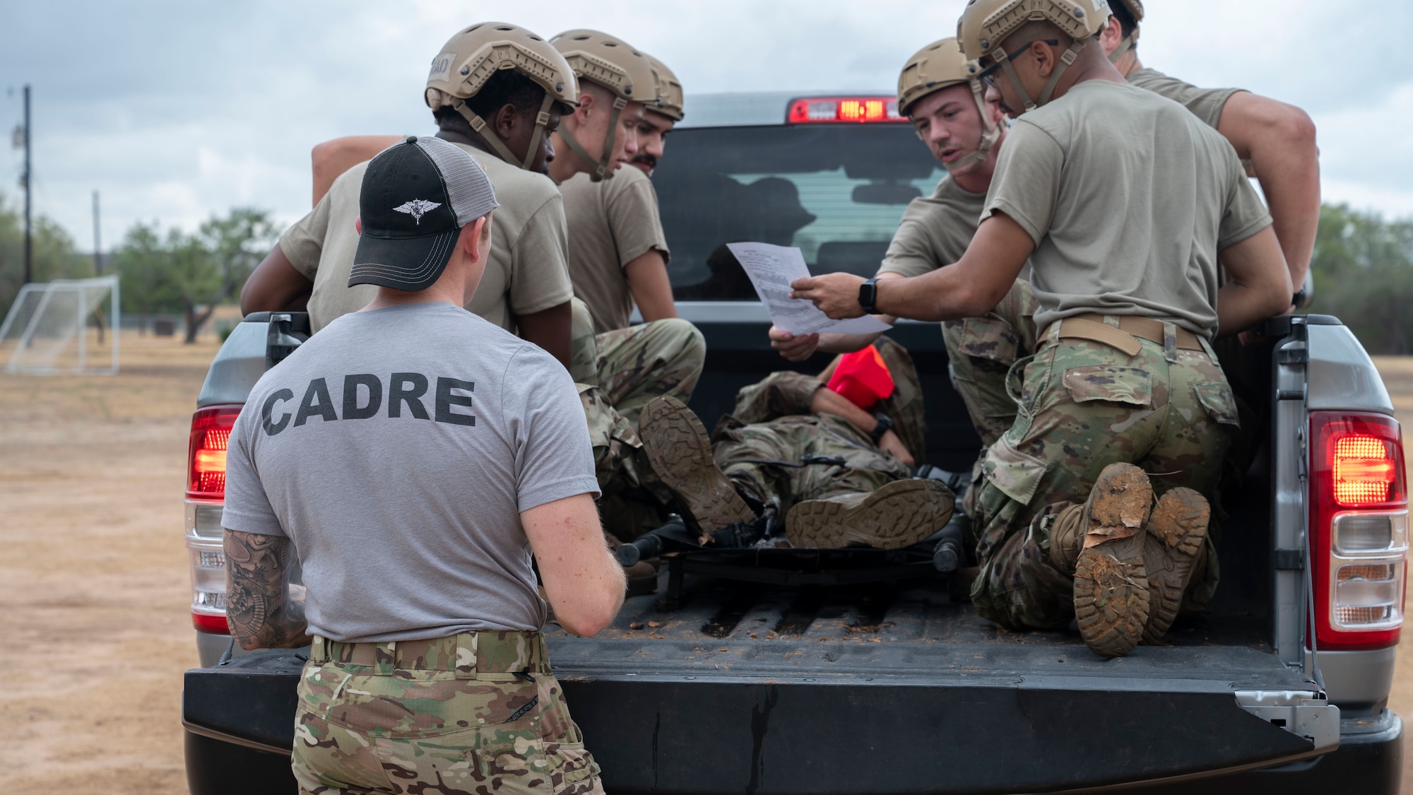 A cadre member from the Special Warfare Training Wing briefs AFROTC cadets in the bed of a truck before they embark on a simulated personnel recovery mission