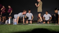 AFROTC cadets work together to get as many push ups as they can in two minutes