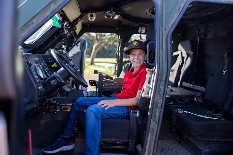 A student from Sunset Hills Elementary School sits inside a U.S. Marine Corps Joint Light Tactical Vehicle assigned to Marine Air Control Group 38, 3rd Marine Wing, during the school's annual Veterans Day program in San Diego, California, Nov. 7, 2024. The event featured active-duty Marines who presented equipment and engaged with students and parents about their military service. (U.S. Marine Corps photo by Sgt. Santicia Ambriez-Stippey)
