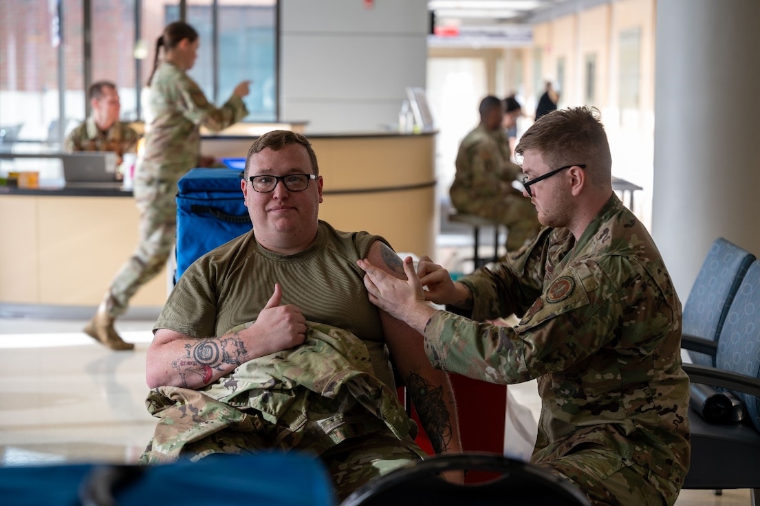 Airman gives thumbs up while receiving a flu shot vaccine. (U.S. Air Force photo by Airman Donnell Ramsey)