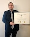 Scott Robison, an Army Reserve civilian and budget analyst for the 84th Training Command poses with his certificate from receiving the Certified Defense Financial Manager certification. To obtain this certification, candidates must meet a combination of education and job experience requirements and pass three proctored multiple-choice exams.