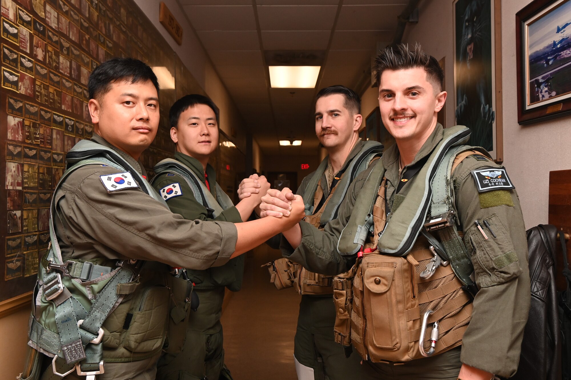 U.S. Air Force Capt. Jacob Herrick, center-right, 35th Fighter Squadron F-16 pilot, and Capt. Christopher Cochran, right, 35th FS F-16 pilot, shake hands with Republic of Korea Air Force KF-16 pilots during Buddy Squadron 24-6 at Kunsan Air Base, R.O.K.