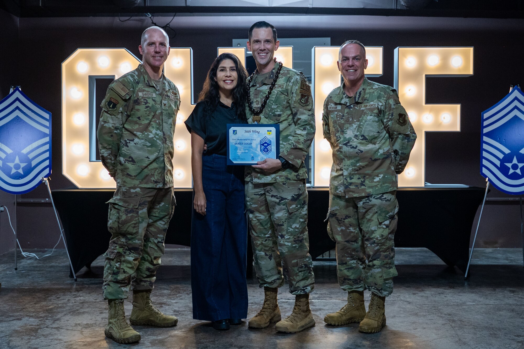 Team Andersen celebrates with new Chief Master Sgt. select, Senior Master Sgt. James Colip, 736th Security Forces Squadron Operations superintendent and his wife during a chief release party at Andersen Air Force Base, Guam, Nov. 14, 2024. (U.S. Air Force photo by Airman 1st Class Audree Campbell)