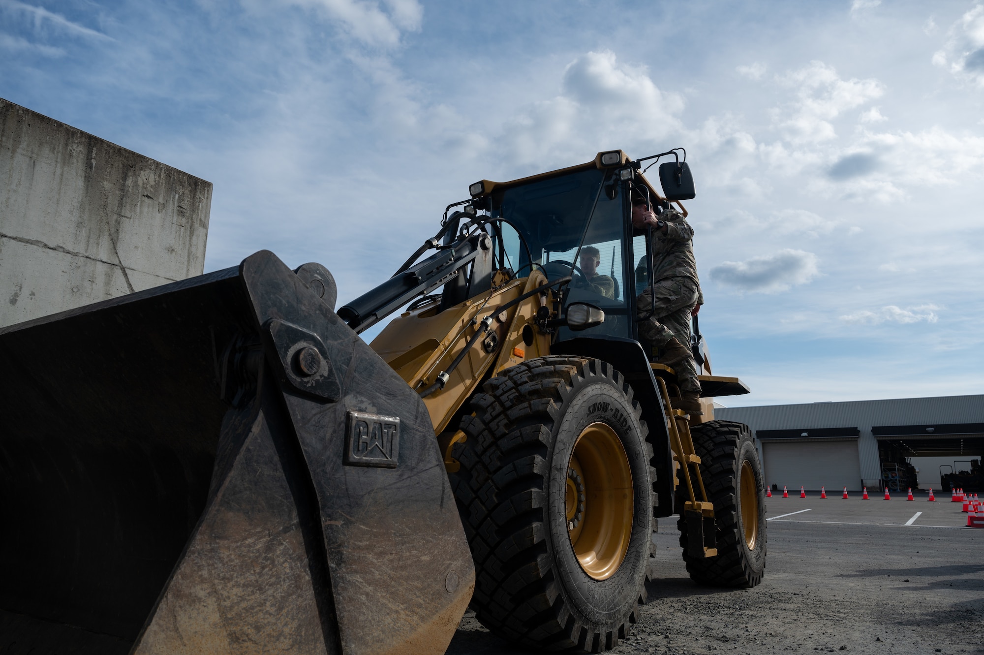 A U.S. Air Force Airman, assigned to the 35th Civil Engineer Squadron, demonstrates how to operate a Front-end Loader for a Snow Rodeo