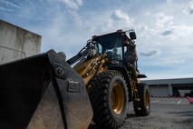 A U.S. Air Force Airman, assigned to the 35th Civil Engineer Squadron, demonstrates how to operate a Front-end Loader for a Snow Rodeo
