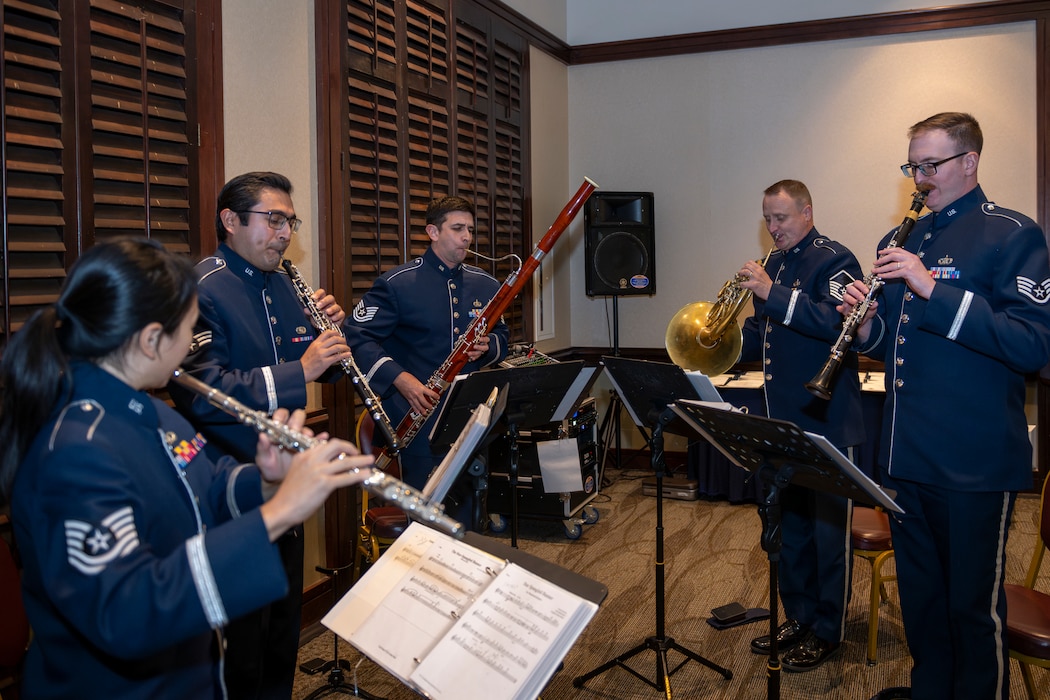 Airmen assigned to the Band of the Golden West play music during a ceremony