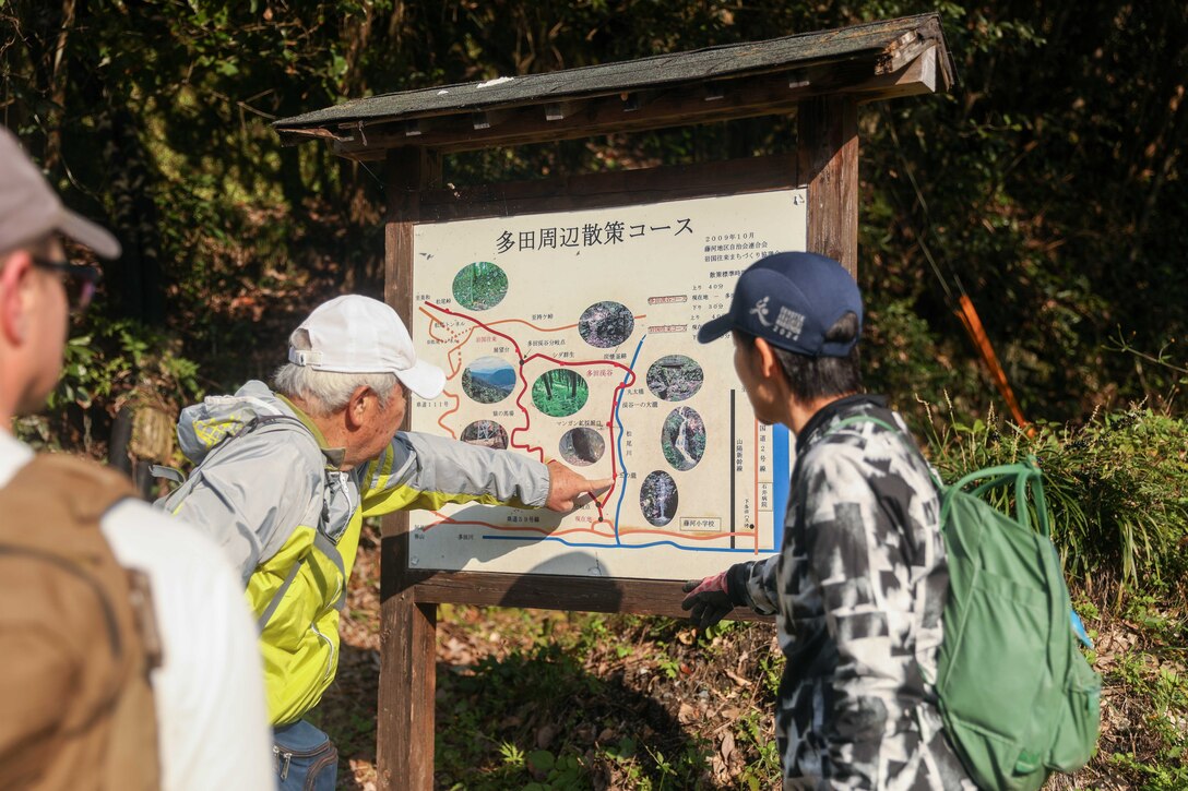 Katsuhiko Fujimori, left, leader of cleanup and maintenance for the “Old Samurai Path”, explains the route up the trail before a cleanup and maintenance of the “Old Samurai Path” in Tada, Iwakuni, Japan, Nov. 5, 2024. Since 2005, volunteers from MCAS Iwakuni regularly help locals maintain the path to reinforce the relationship between MCAS Iwakuni and the local Japanese community. (U.S. Marine Corps photo by Lance Cpl. Colin Thibault)