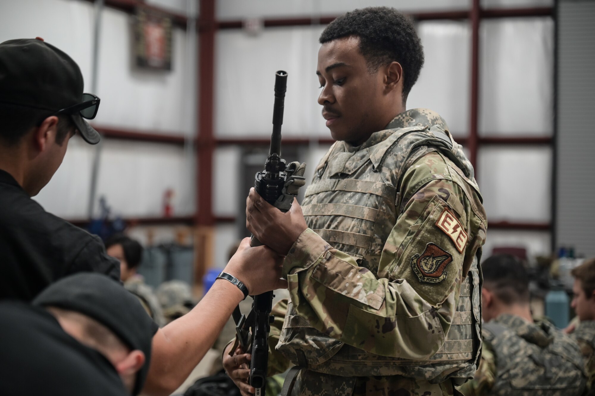 Airmen is handed a rifle during training.