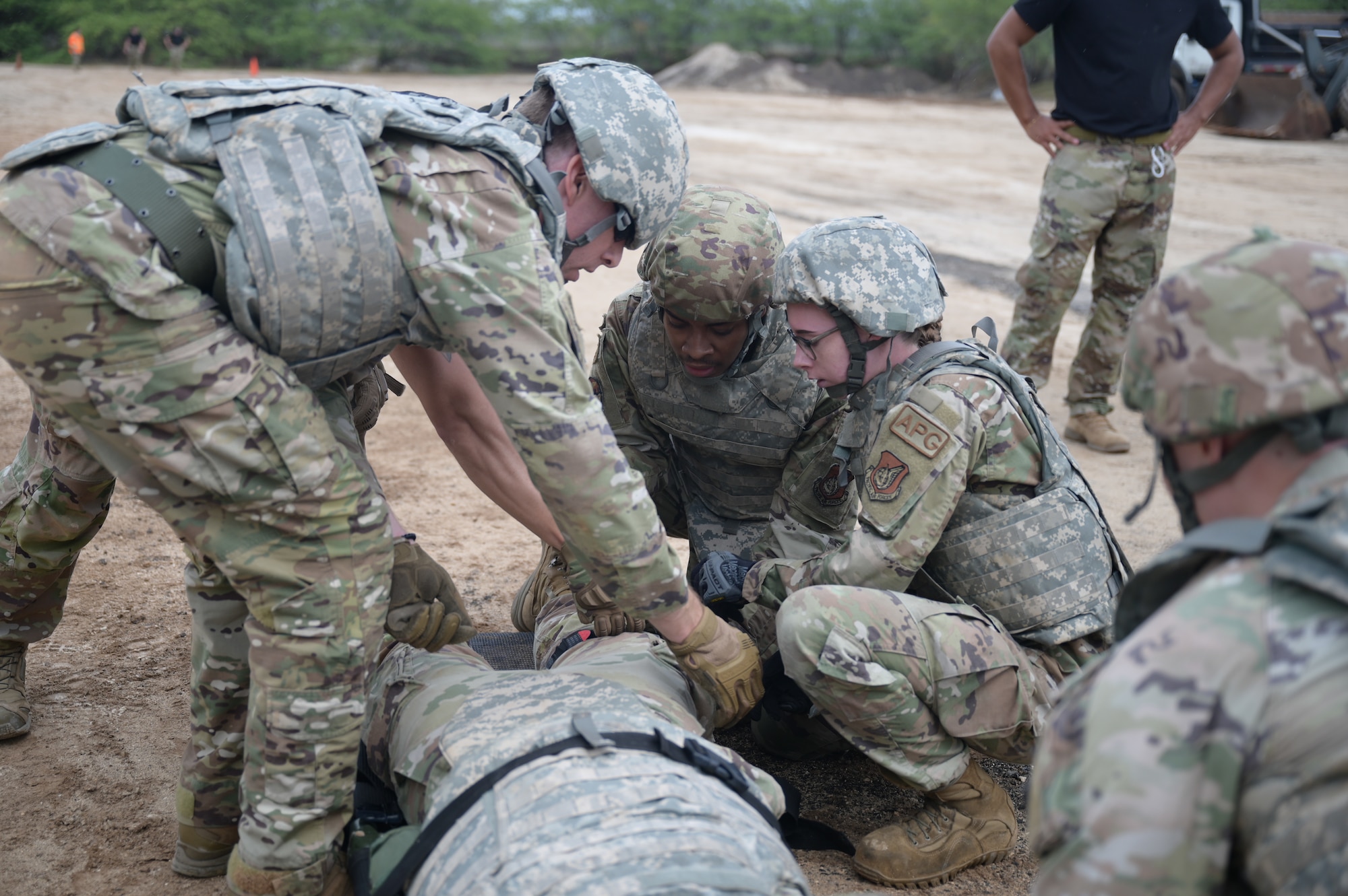 Airmen secure simulated patient to litter.