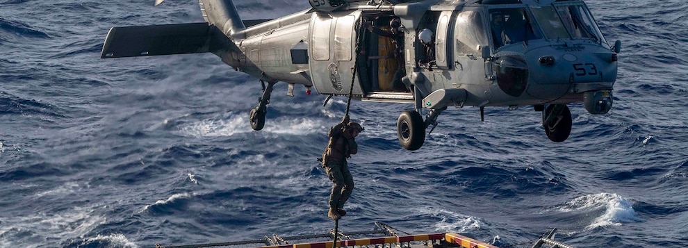 A U.S. Marine assigned to the 15th Marine Expeditionary Unit (MEU) fast ropes from a MH-60S Knighthawk Helicopter assigned to the “Wildcards” of Helicopter Sea Combat Squadron (HSC) 23 during an air power demonstration rehearsal as the Wasp-class amphibious assault ship USS Boxer (LHD 4) steams in the Pacific Ocean, Nov. 10, 2024.