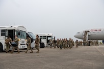 Airmen attached to the 20th Expeditionary Bomb Squadron board shuttle buses