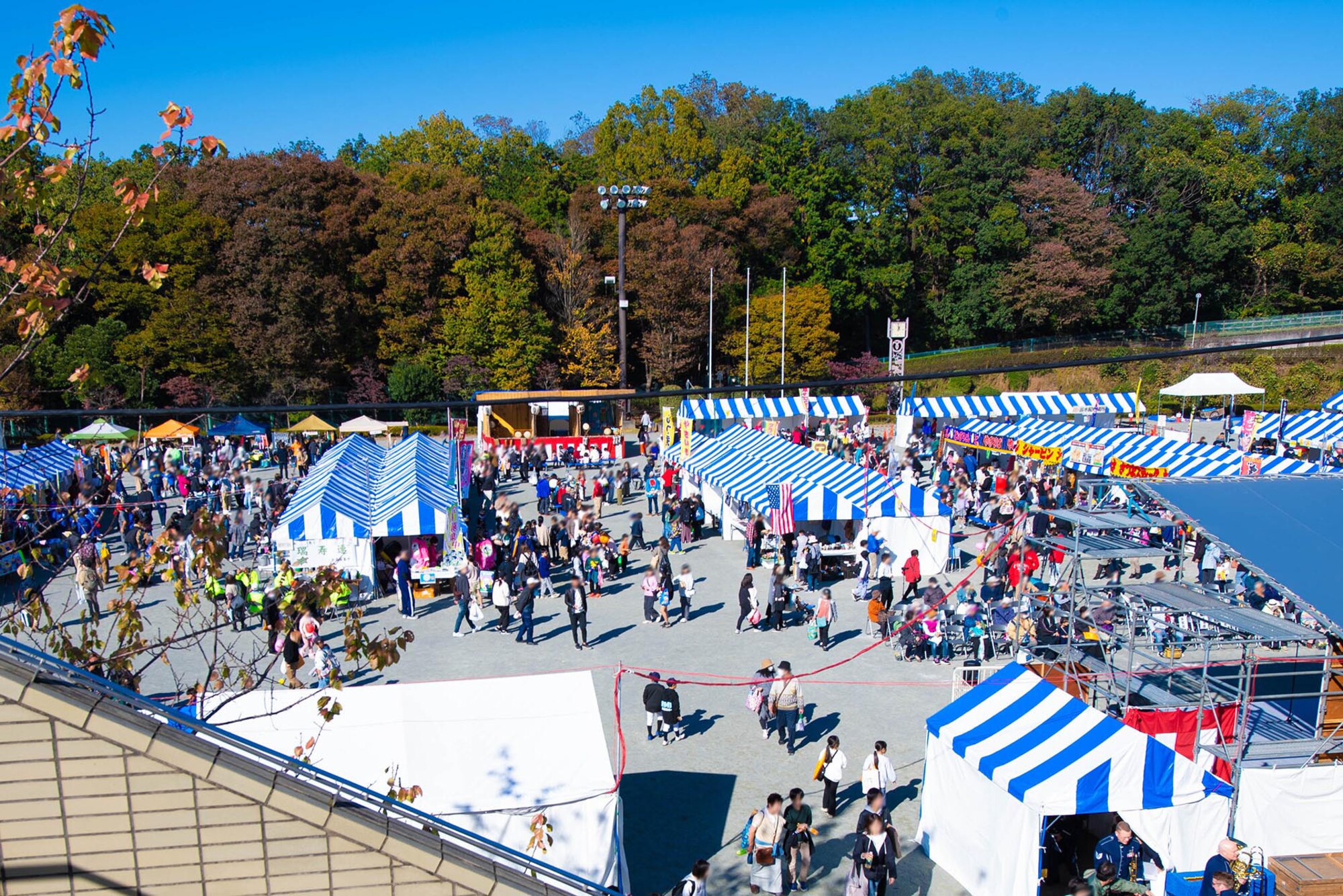 People walk around a festival area.