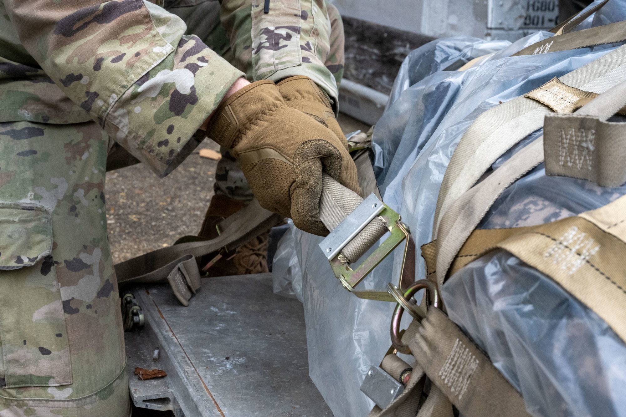 U.S. Air Force Staff Sgt. William Riner, 100th Logistics Readiness Squadron air transportation function supervisor, tightens the straps on a cargo pallet at Royal Air Force Mildenhall, England, Nov. 5, 2024.