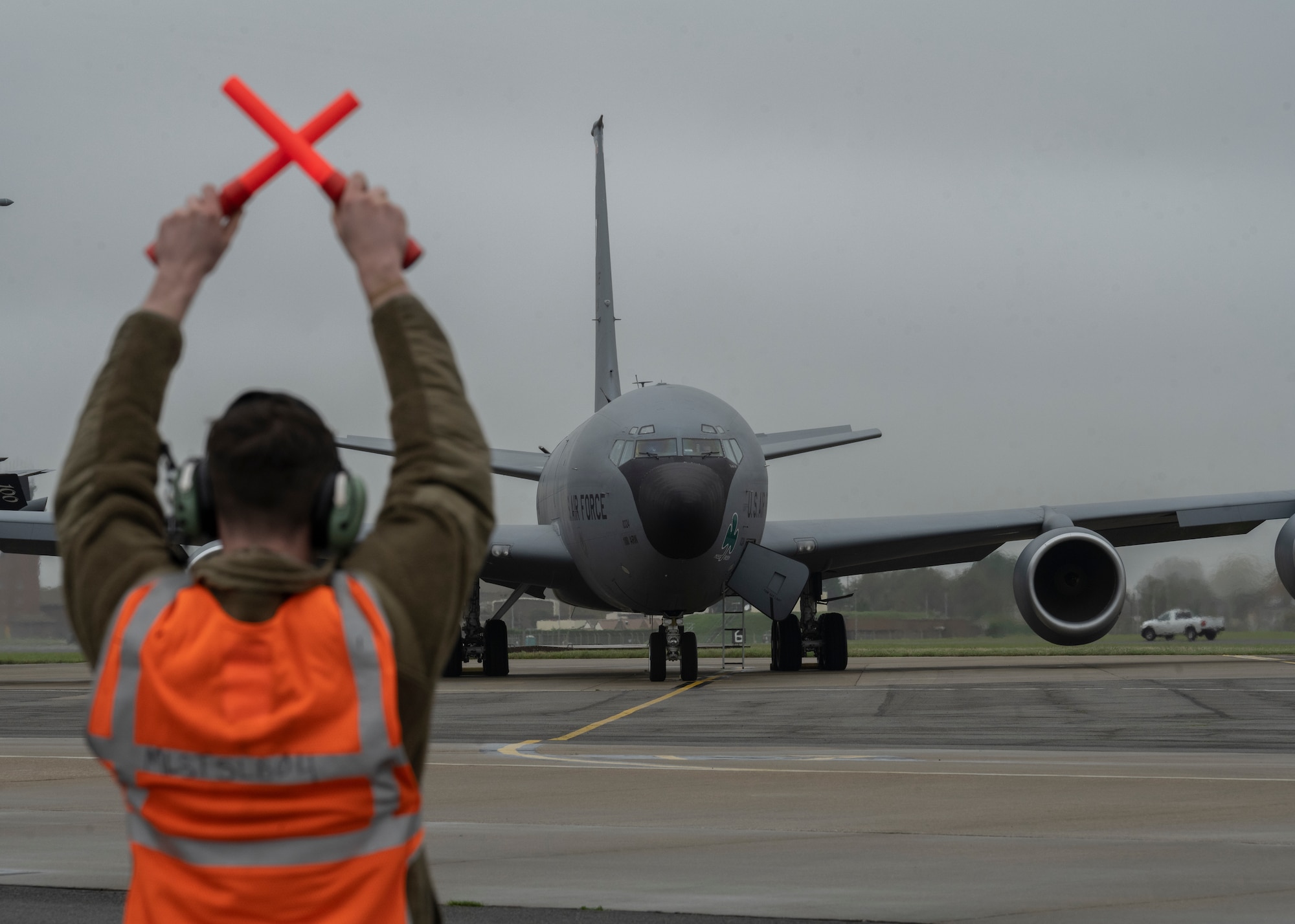 A U.S. Air Force Airman marshalls a KC-135 Stratotanker onto the runway at Royal Air Force Mildenhall, England, Nov. 6, 2024.