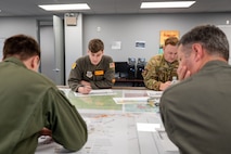 Members of the 16th Airlift Squadron review mission plans during Battalion Mass Tactical Week at Fort Liberty, North Carolina, Nov. 13, 2024.