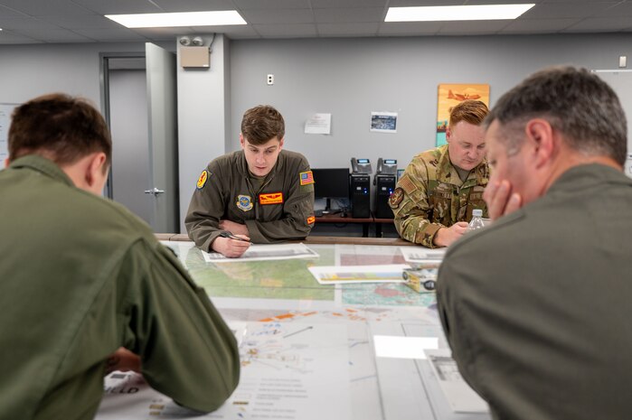 Members of the 16th Airlift Squadron review mission plans during Battalion Mass Tactical Week at Fort Liberty, North Carolina, Nov. 13, 2024.