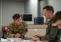 U.S. Air Force Senior Airman Ethan Weatherford, 16th Airlift Squadron loadmaster, and Chief Master Sgt. Danny South, 16th AS senior enlisted leader, discuss load plans during mission planning for Battalion Mass Tactical Week at Fort Liberty, North Carolina, Nov. 13, 2024.