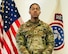 Male Soldier posed in front of the U.S. flag and USAREC flag.