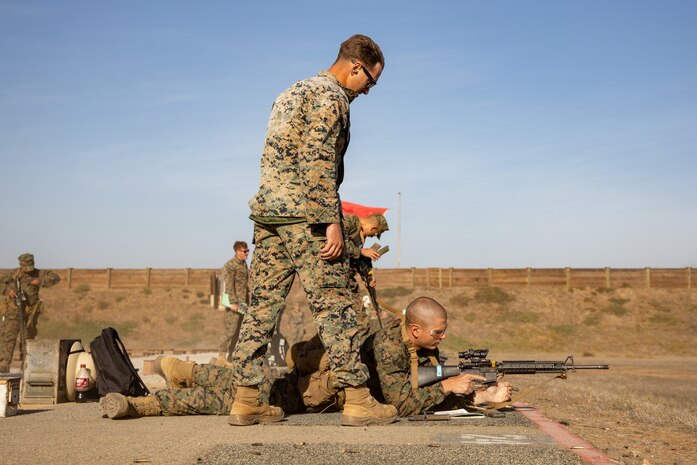 U.S. Marine Corps Cpl. Toby Smith, a combat marksmanship coach with Weapons and Field Training Battalion, Recruit Training Regiment, assists a recruit with Kilo Company, 3rd Recruit Training Battalion, during the table one course of fire at the 300-yard line at Marine Corps Base Camp Pendleton, California, Nov. 6, 2024. Table one covers the basic fundamentals of marksmanship and rifle safety in all shooting positions: sitting, kneeling, and the prone. (U.S. Marine Corps photo by Lance Cpl. Janell B. Alvarez)