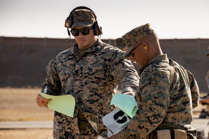 U.S. Marine Corps Sgt. Ahmad Nasrallah, a combat marksmanship coach with Weapons and Field Training Battalion, Recruit Training Regiment, hands a score sheet to Rct. Deveron Yarbrough with Kilo Company, 3rd Recruit Training Battalion, during the table one course of fire at Marine Corps Base Camp Pendleton, California, Nov. 6, 2024. Table one covers the basic fundamentals of marksmanship and rifle safety in all shooting positions: sitting, kneeling, and the prone. (U.S. Marine Corps photo by Lance Cpl. Janell B. Alvarez)
