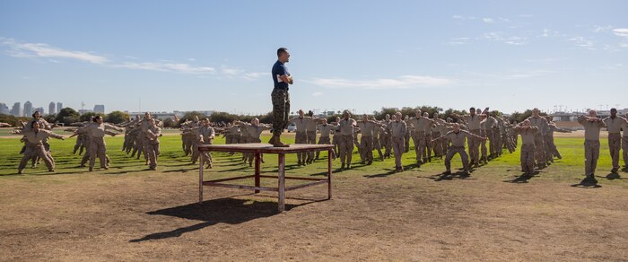 U.S. Marine Corps Staff Sgt. Rudy Dominguez, chief drill instructor with Lima Company, 3rd Recruit Training Battalion, leads recruits in conducting dynamic warm-ups prior to the introduction of the combat fitness test at Marine Corps Recruit Depot San Diego, California, Oct 30, 2024. The recruits were introduced to the CFT by conducting different portions of the test separately. The CFT is an annual fitness test that is required of all Marines to pass and maintain consisting of an 880-yard sprint, ammunition can lifts, and a maneuver under fire drill. (U.S. Marine Corps photo by Lance Cpl. Janell B. Alvarez)