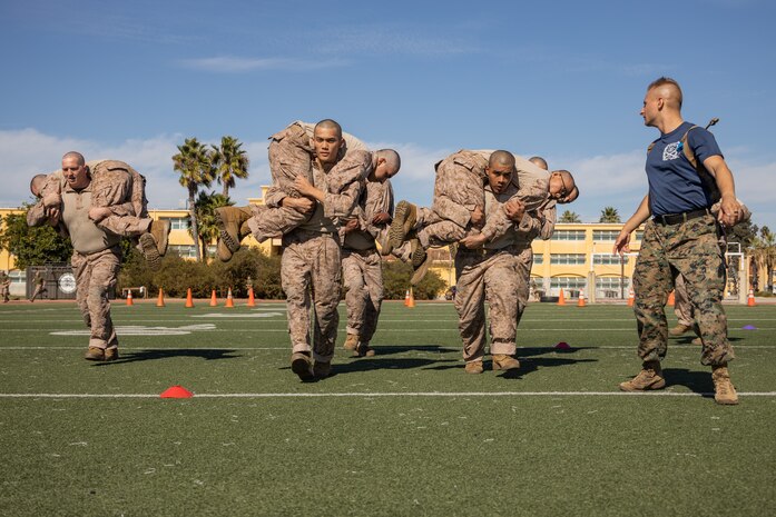U.S. Marine Corps recruits with Lima Company, 3rd Recruit Training Battalion, execute the fireman’s carry during the maneuver under fire portion of a combat fitness test event at Marine Corps Recruit Depot San Diego, California, Oct. 30, 2024. The CFT is a test that all recruits must pass and maintain once a year to assess combat readiness as well as physical conditioning. (U.S. Marine Corps photo by Lance Cpl. Janell B. Alvarez)
