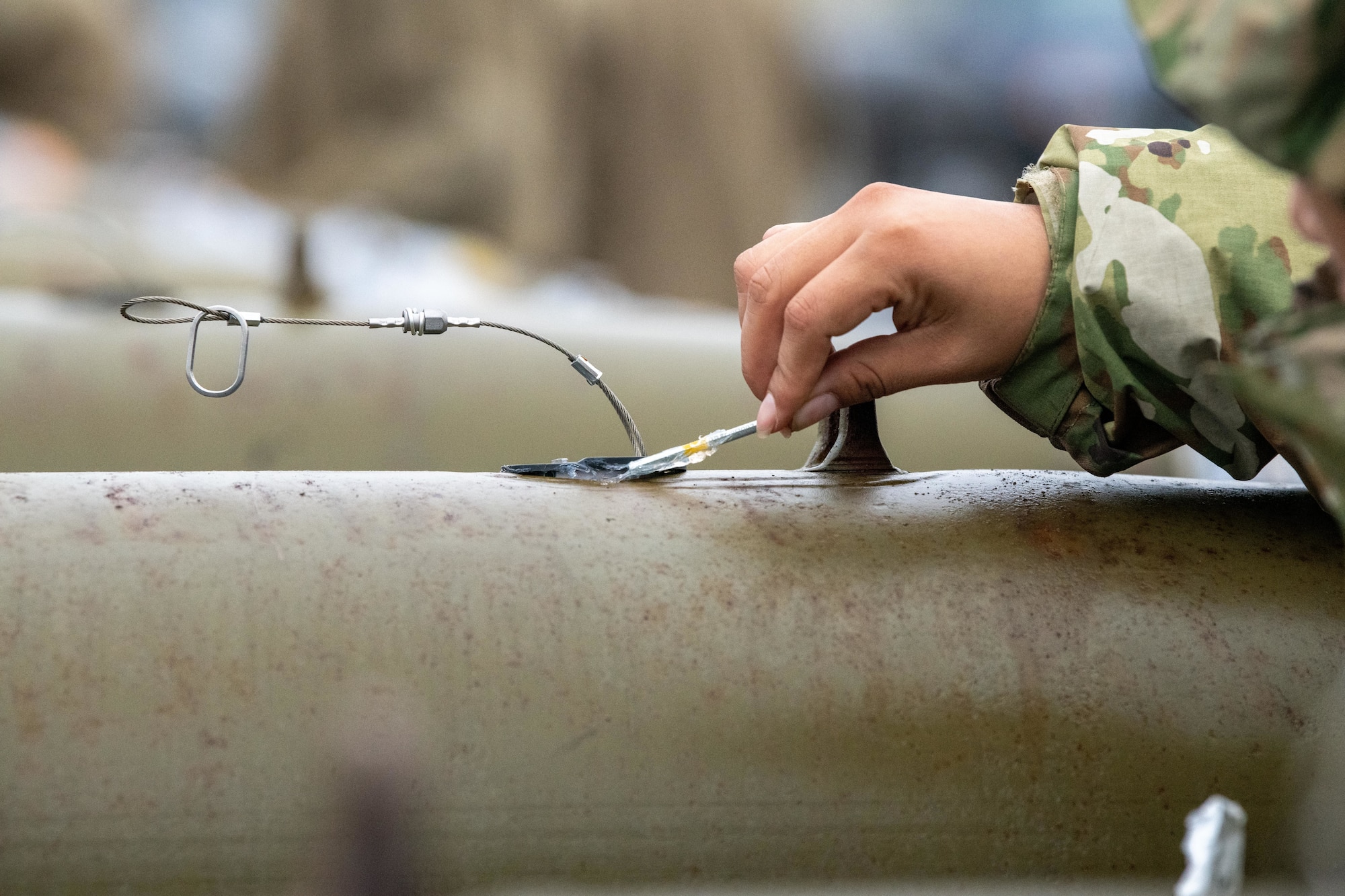 Airman applies room temperature vulcanization to a GBU-38 Joint Direct Attack Munitions