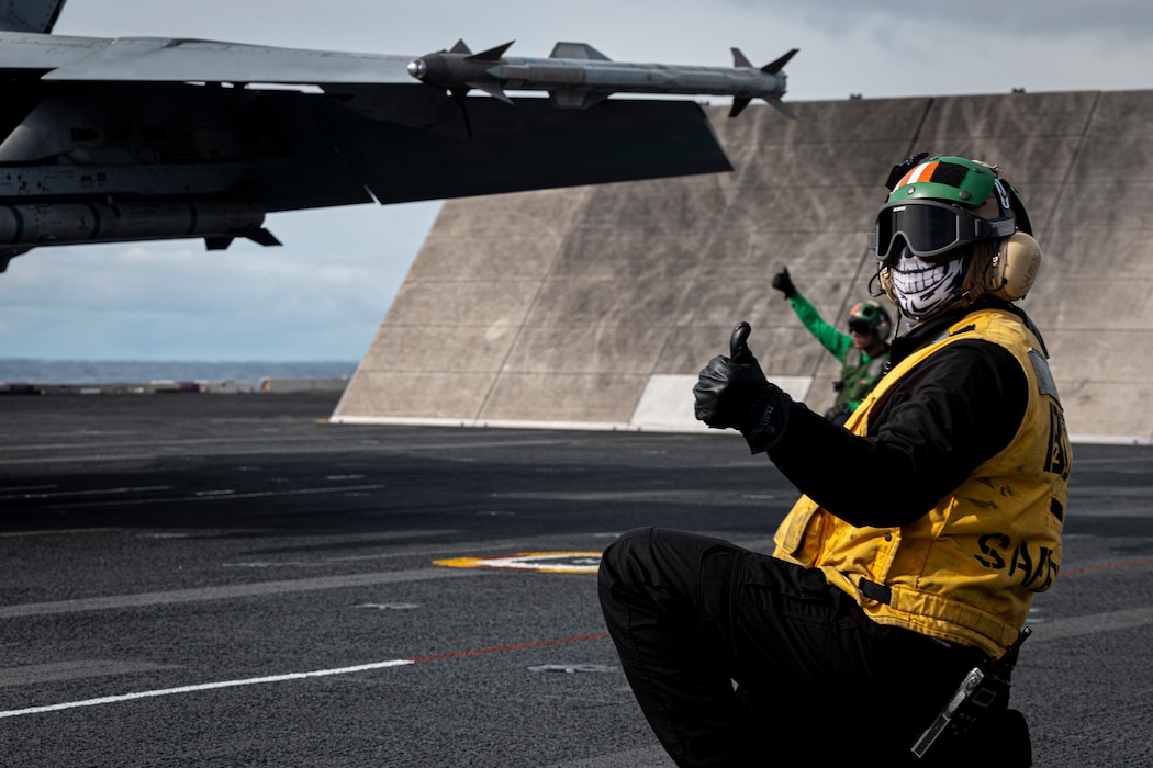 ABE2 Joshua Juco, assigned to air department aboard the world's largest aircraft carrier, USS Gerald R. Ford (CVN 78), signals the catapult for launch