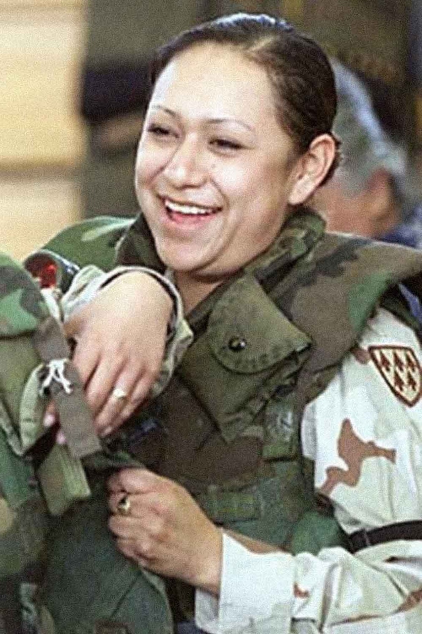 A woman in uniform smiles.