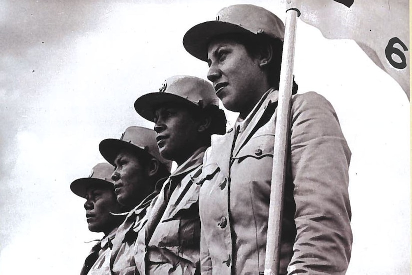 Four women in uniform stand at attention.