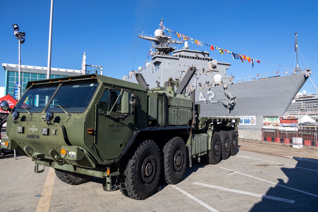 A U.S. Marine Corps Logistics Vehicle System Replacement assigned to I Marine Expeditionary Force is staged alongside the USS Germantown during Fleet Week San Diego at Broadway Pier, San Diego, Nov. 9, 2024. FWSD is an opportunity for San Diego residents and tourists to meet their Navy, Marine Corps and Coast Guard teams and experience America’s sea services. During fleet week, service members participate in various community relations events, showcase capabilities and equipment to the community, and enjoy the hospitality of San Diego and the surrounding area. (U.S. Marine Corps photo by Sgt. Gabriel Tavarez)