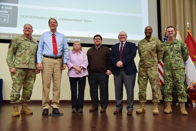 A group of people stand in a single line on a stage.