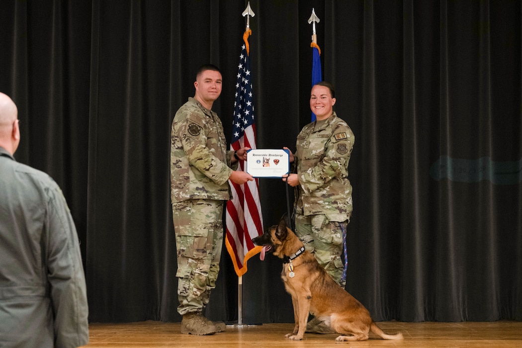 Dog and handler receive a document on stage