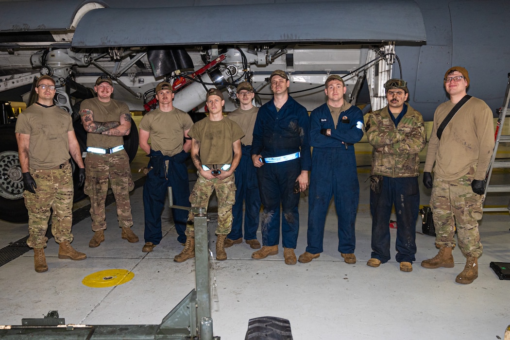 Airmen of the 62d Maintenance Group stand in front of an ongoing main landing gear axle replacement at Joint Base Lewis-McChord, Washington, Nov. 13, 2024.