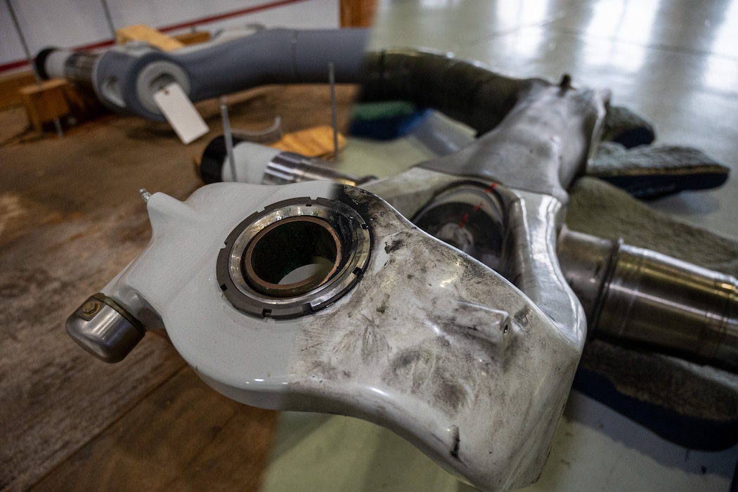 A photo of new main landing gear axle for a C-17 Globemaster III, left, is merged together with a photo of a removed axle during a C-17 main landing gear axle replacement at Joint Base Lewis-McChord, Washington, Nov. 13, 2024.