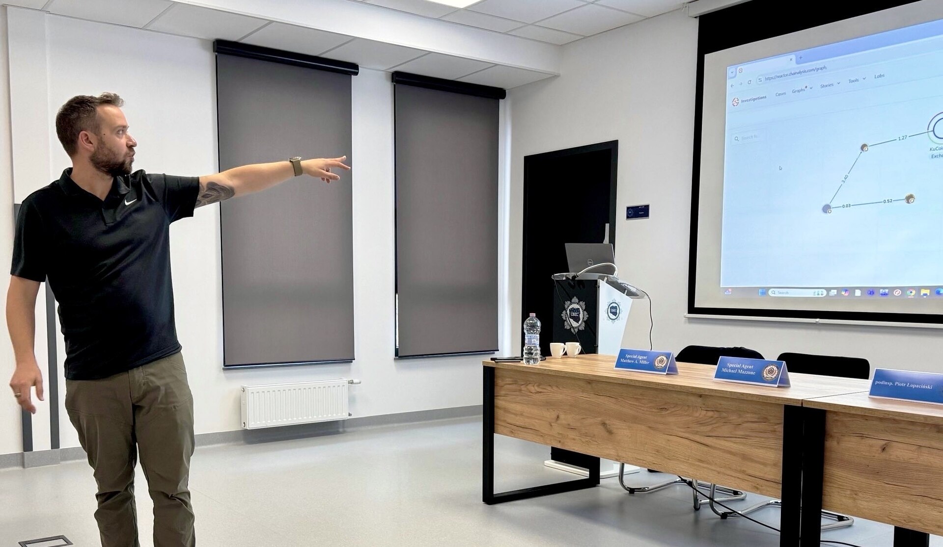 Army CID Special Agent points at screen while instructing in a classroom