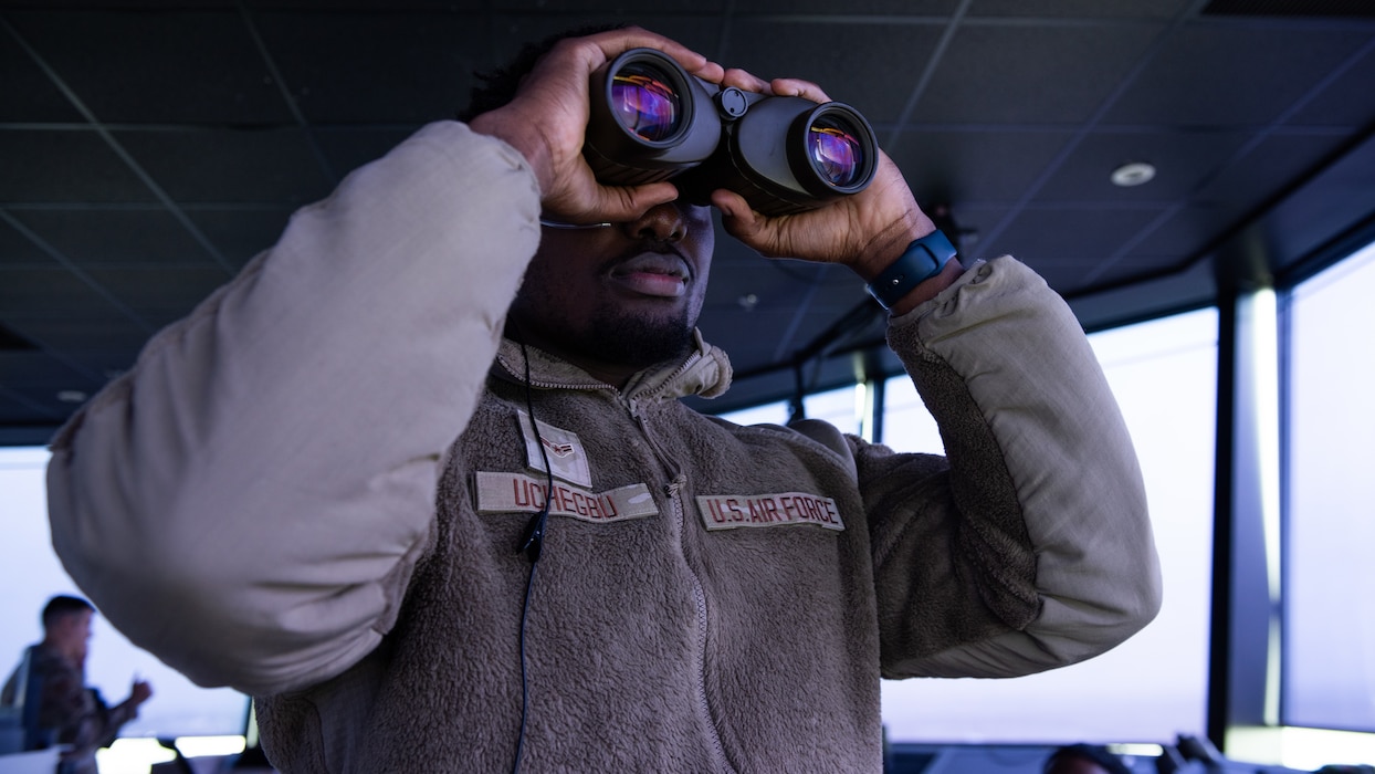 Airman using binoculars to search for inbound aircraft