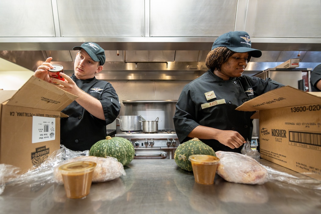 Airmen open boxes of food.