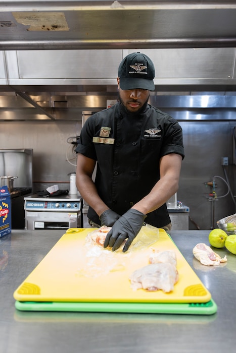 Airman prepares chicken.