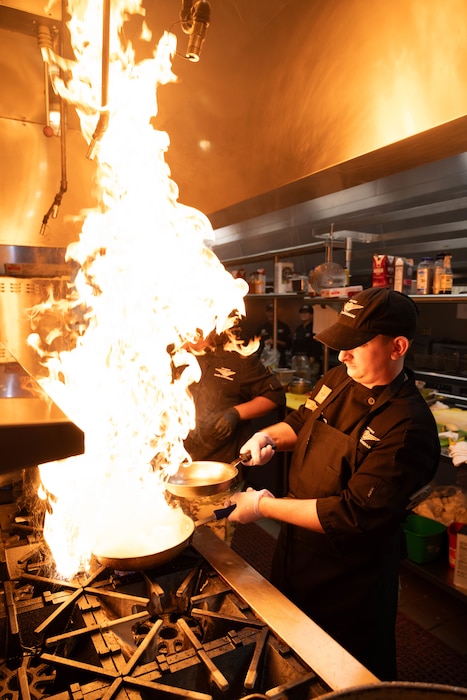 Airman cooks food on stove.