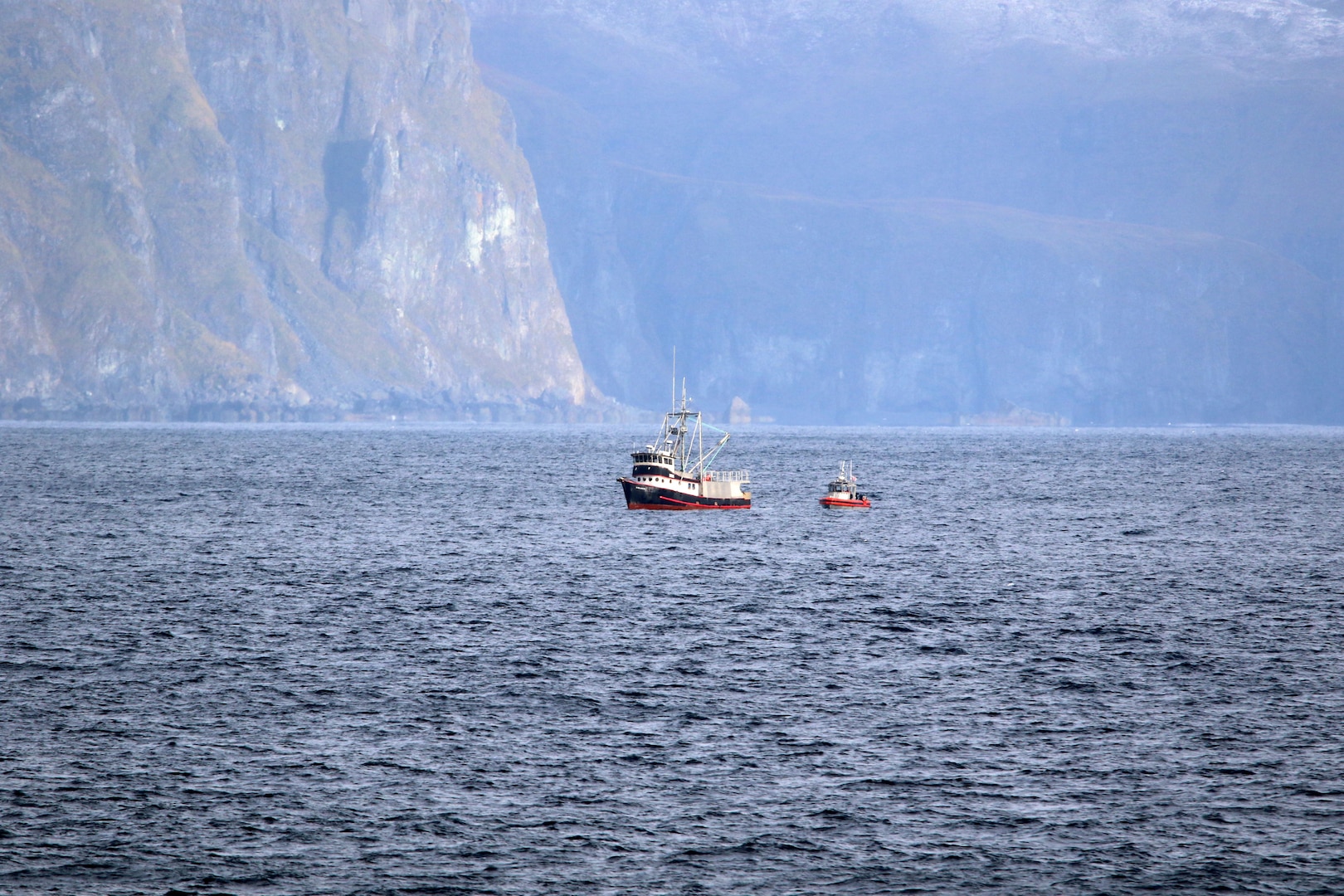 A Coast Guard Cutter Stratton (WMSL 752) small boat pulls alongside the disabled and adrift fishing vessel Galatea, Unalaska Island, Alaska, Oct. 13, 2024. Stratton responded to the Galatea, which was adrift in a storm without propulsion due to a severed engine cooling line and the crew deployed to the fishing vessel, repaired the casualty, and safely escorted Galatea to Dutch Harbor. U.S. Coast Guard courtesy photo.