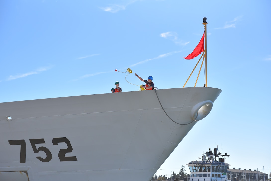 A crewmember aboard the Coast Guard Cutter Stratton (WMSL-752) tosses a heaving line to the pier as the Stratton returns home to its homeport of Alameda, Calif., Nov. 4, 2024. The Stratton's crew returned home from a months-long Bering Sea Patrol where the crew conducted fisheries law enforcement to protect living marine resources. (U.S. Coast Guard photo by Chief Petty Officer Levi Read/released)