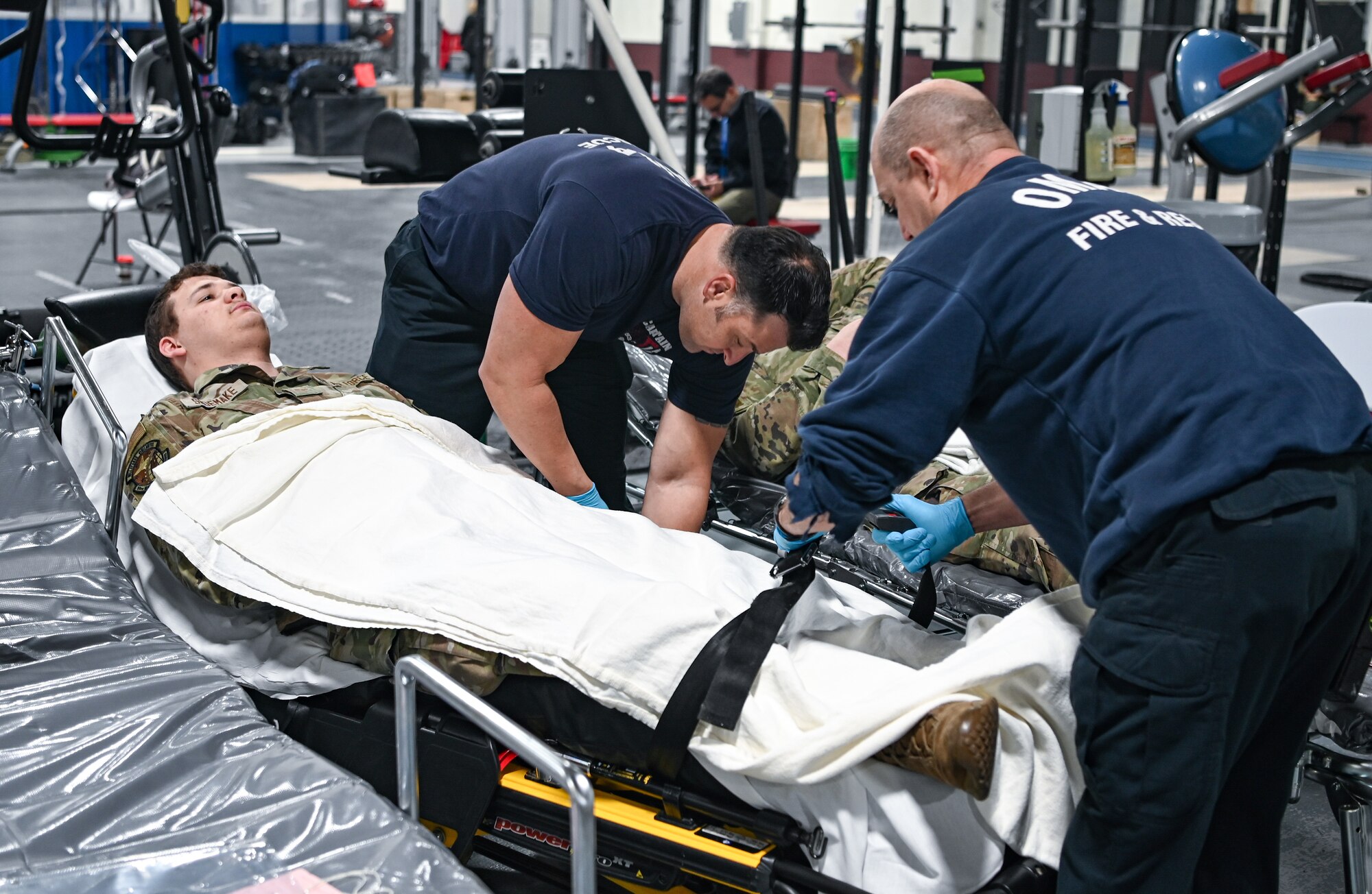 People strap in a patient onto a stretcher