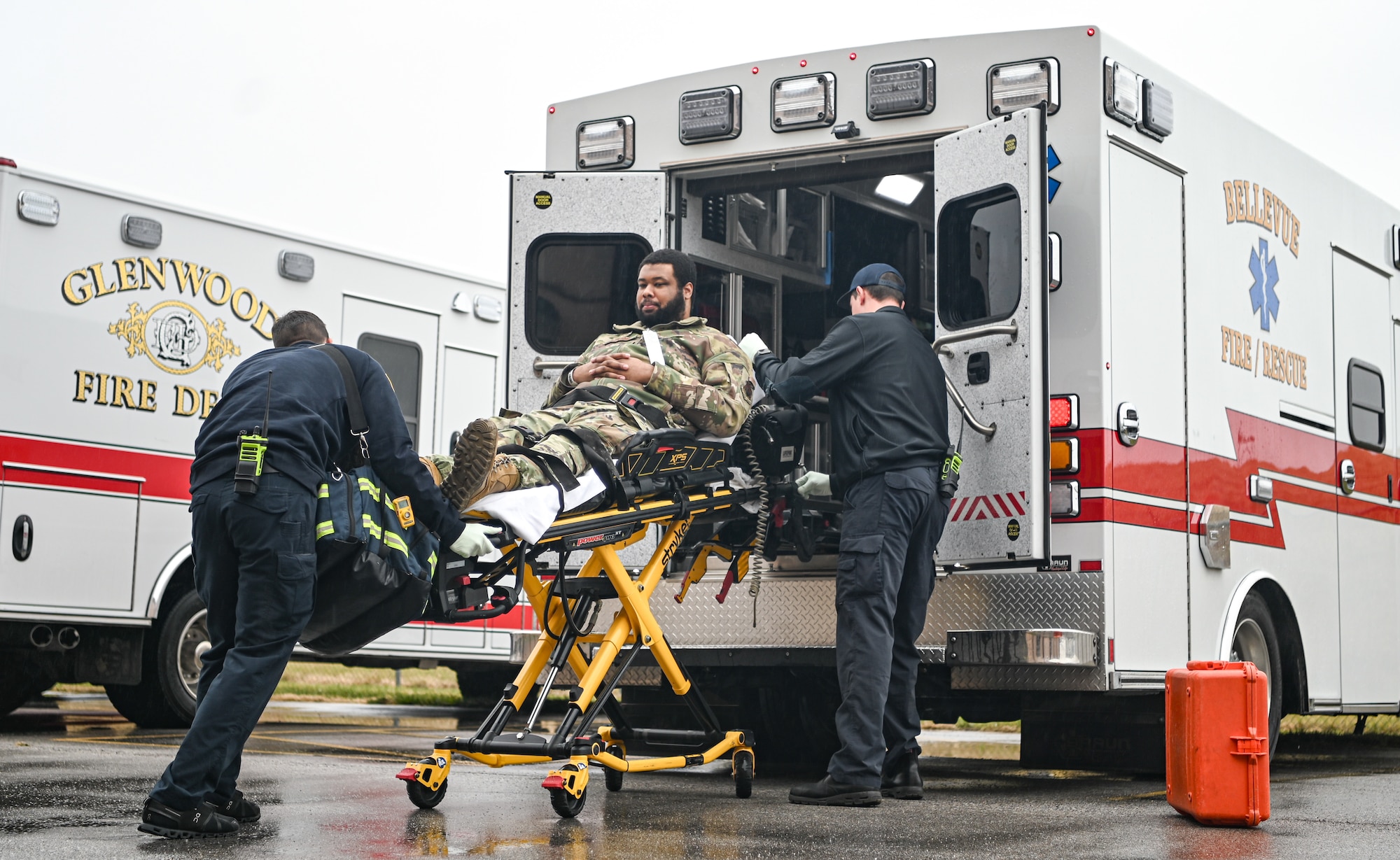 Person lays on stretcher while being loaded into ambulance