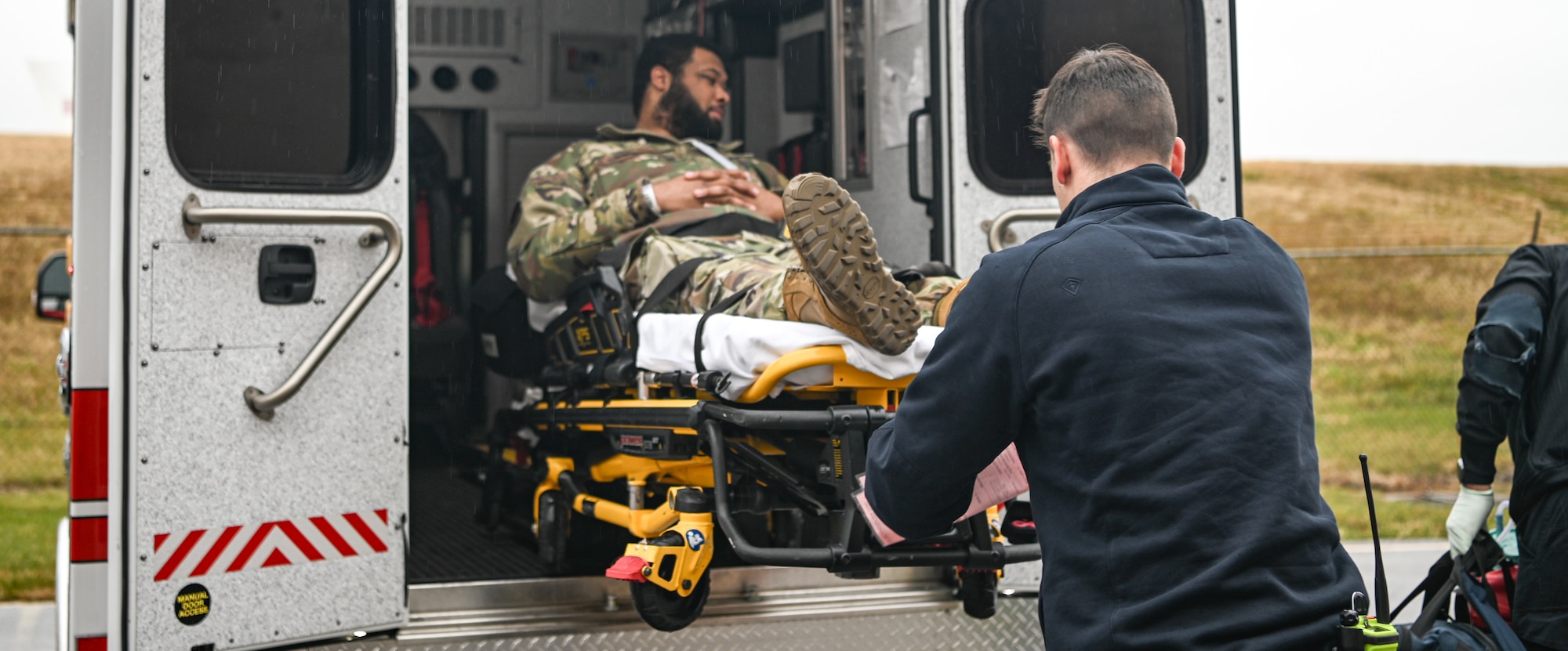 Person lays on stretcher while being loaded into ambulance