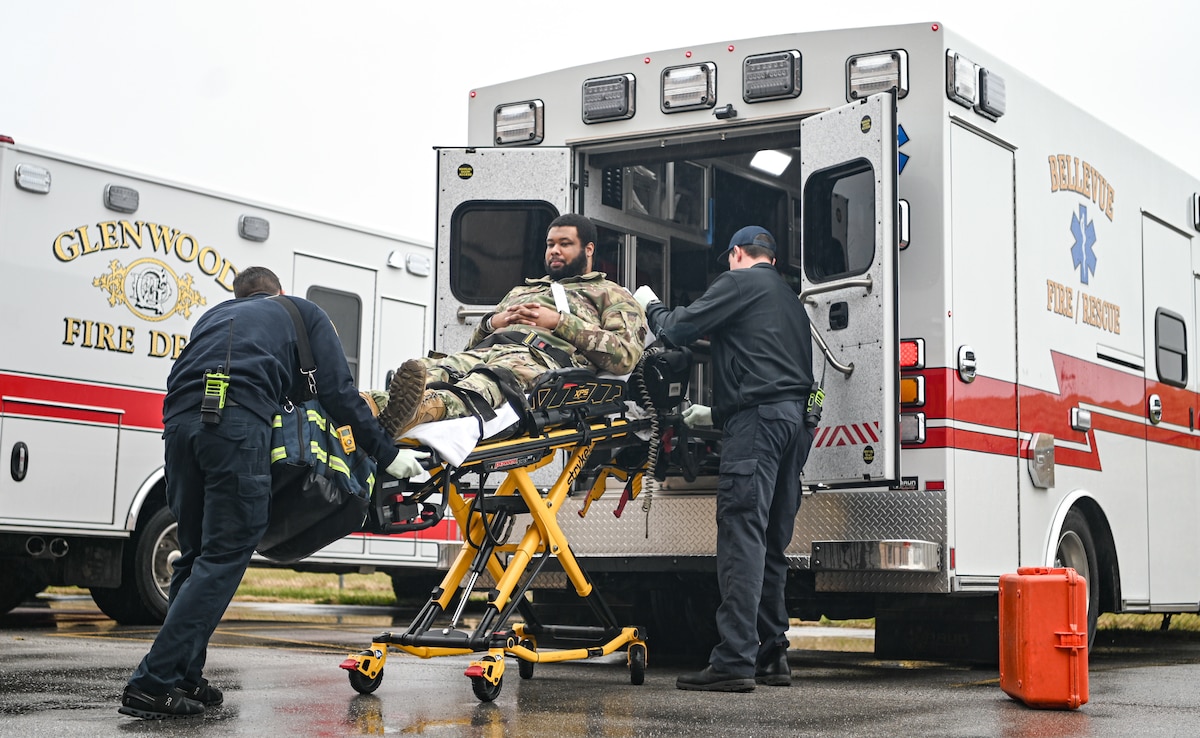 Person lays on stretcher while being loaded into ambulance