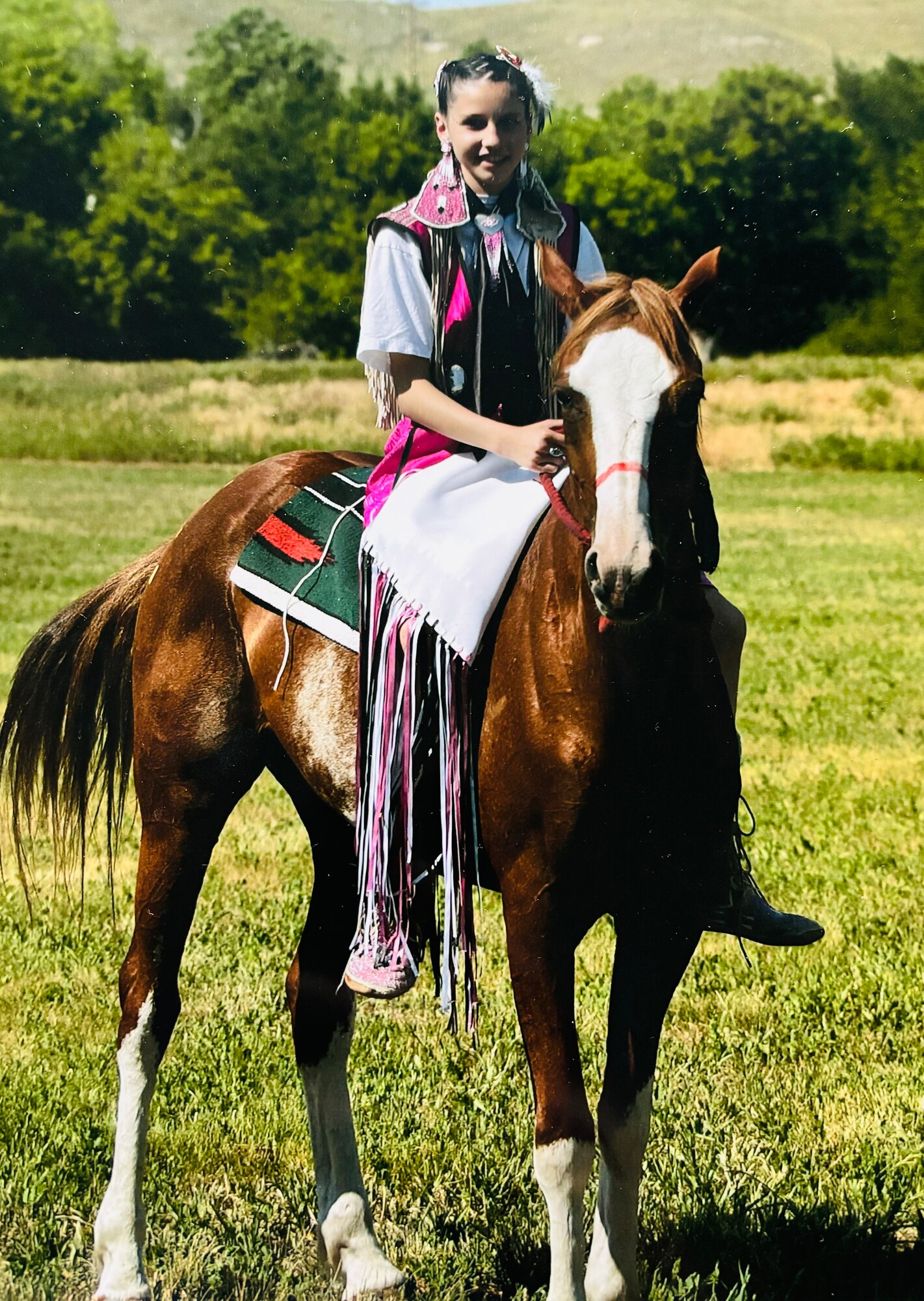 U.S. Air Force Staff Sgt. Casara Pines rides a horse at the age of 11 at a farm on Pine Ridge Reservation in Pine Ridge, South Dakota in 2001. Pine wore her regalia and rode a horse on the farm named Jade. (Courtesy photo provided by Casara Pine)